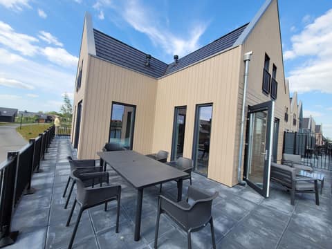 Außenansicht des Ferienhauses mit großer Terrasse und Sitzgruppen